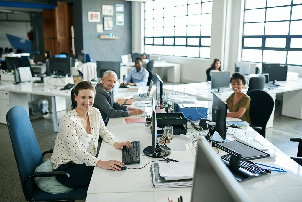 Portrait of a group of coworkers sitting at their workstations in an office